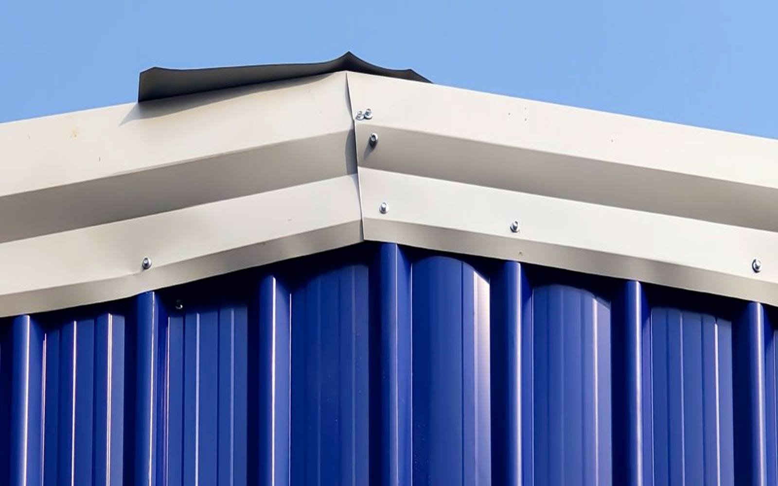 Formed white metal cap flashing seam on a corrugated wall