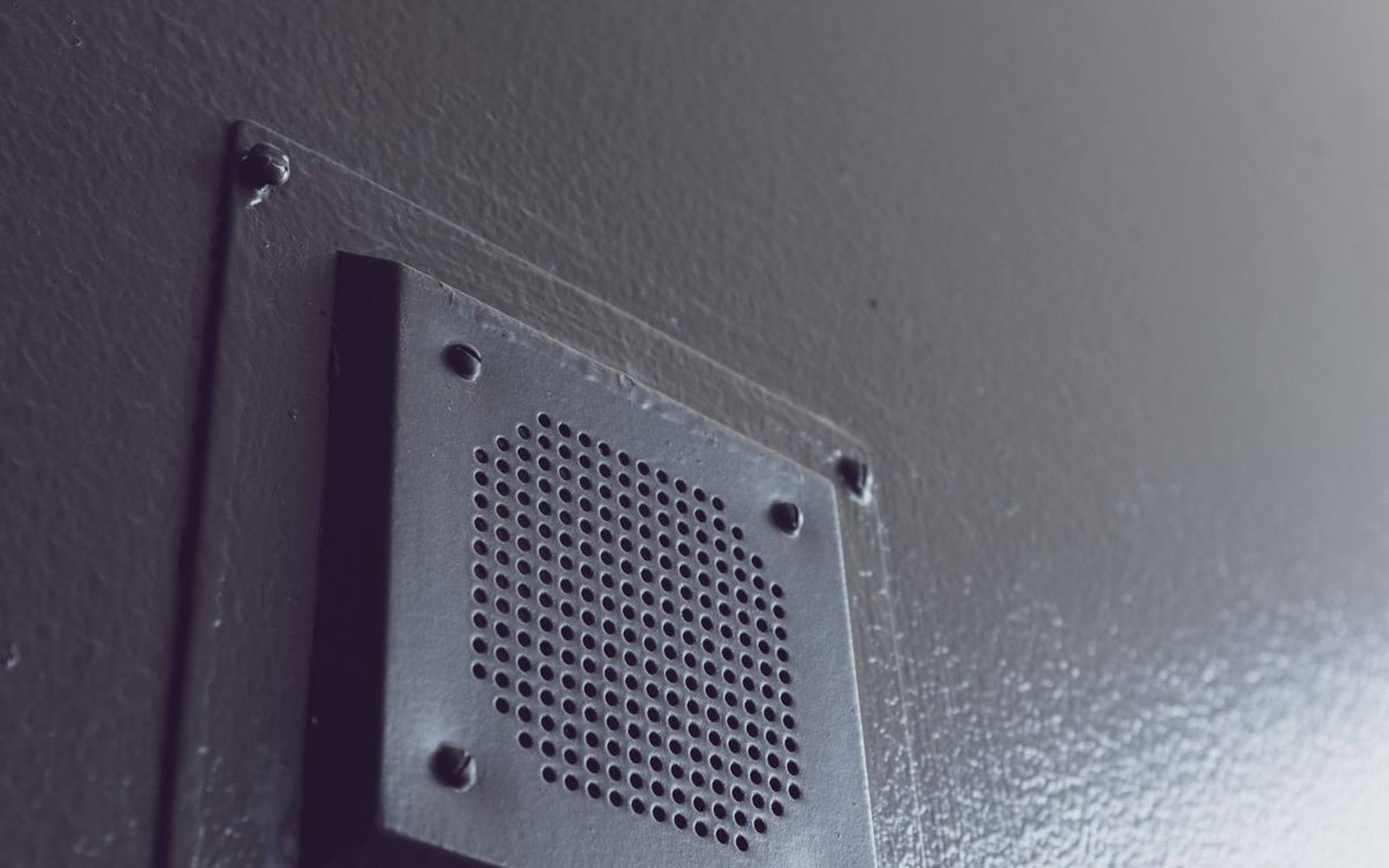 Metal vent trim set into a textured exterior wall